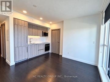 Toronto (Waterfront Communities) condo for rent - A spacious kitchen with wooden cabinets and a white countertop.