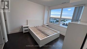 Richmond Hill (Beaver Creek Business Park) condo for rent - A bedroom with a large bed and a window overlooking a snowy landscape.