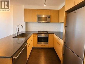 Richmond apartment for rent - A kitchen with wooden cabinets and stainless steel appliances.