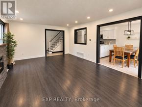 Brampton (Brampton North) townhouse for rent - A spacious room with wooden flooring and a dining area in the background.