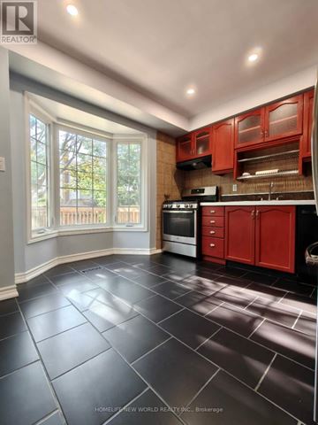 Aurora (Aurora Village) apartment for rent - A kitchen with red cabinets and black tile flooring.