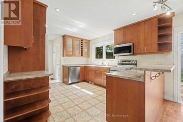 Ottawa apartment for rent - A kitchen with wooden cabinets and a stainless steel dishwasher.