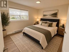 St. John's multi-family for rent - A bedroom with a large bed and a painting on the wall.
