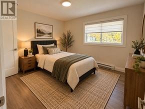 St. John's multi-family for rent - A bedroom with a bed, nightstands, and a window.