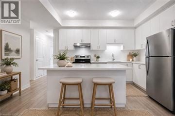 Kitchener townhouse for rent - A modern kitchen with white cabinets and a large island.