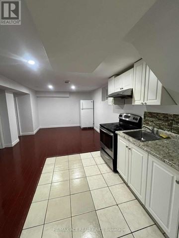 Toronto (Woburn) apartment for rent - A kitchen with white cabinets and a black stove top oven.