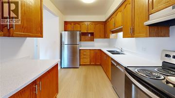 Sarnia townhouse for rent - A kitchen with wooden cabinets and a stainless steel refrigerator.