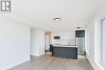 Toronto (Forest Hill North) condo for rent - A modern kitchen with white cabinets and a black island.