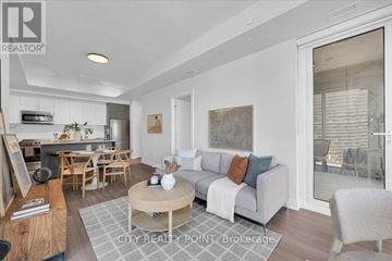 Toronto (University) condo for rent - A well-lit living room with a grey sofa and wooden furniture.