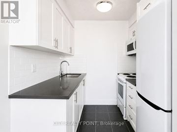 Toronto (Yonge-Eglinton) condo for rent - A kitchen with white cabinets and a black counter top.