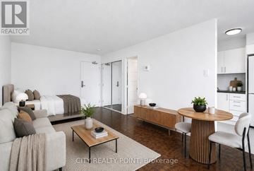 Toronto (Church-Yonge Corridor) condo for rent - A modern living room with a grey sofa and a television.