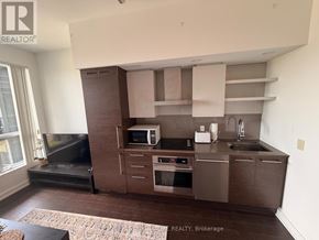Toronto (Niagara) condo for rent - A kitchen with a microwave, oven, and sink.