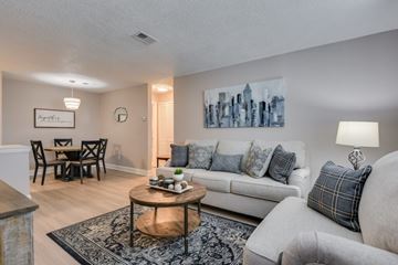Augusta apartment for rent - A living room with a white couch, a wooden coffee table, and a painting on the wall.