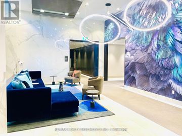 Toronto (Islington-City Centre West) condo for rent - A living room with a blue couch and a large peacock feather mural on the wall.
