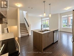London South (South W) townhouse for rent - A modern kitchen with wooden floors and stainless steel appliances.
