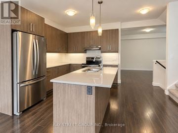 London South (South W) townhouse for rent - A modern kitchen with a stainless steel refrigerator and wooden cabinets.