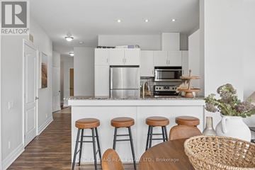 Oshawa (O'neill) condo for rent - A modern kitchen with white cabinets and a bar area.
