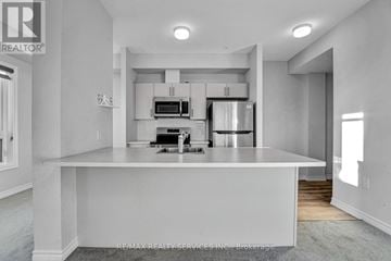 Ottawa condo for rent - A modern kitchen with white cabinets and appliances.