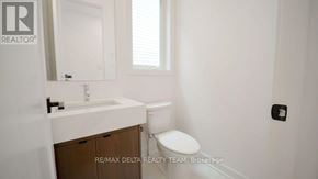 Ottawa apartment for rent - A white bathroom with a toilet, sink and mirror.