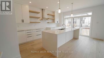Ottawa apartment for rent - A modern kitchen with white cabinets and a central island.