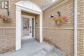 Mississauga (Churchill Meadows) apartment for rent - A white door is in a brick wall with a planter on the wall to the right.