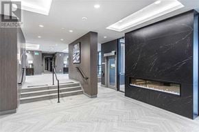 Oakville (Go Glenorchy) condo for rent - A hallway with a marble fireplace and a staircase.