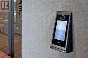 Oakville (Go Glenorchy) condo for rent - A black device with a screen and buttons is mounted on a wall.