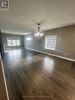 Belleville (Thurlow Ward) apartment for rent - A spacious room with wooden flooring and a chandelier hanging from the ceiling.