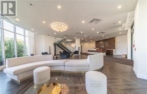 Niagara Falls (Oldfield) condo for rent - A spacious living room with a curved white sofa and a glass coffee table.