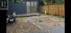 Toronto (Annex) apartment for rent - A backyard with a wooden fence and a small building with a glass door.