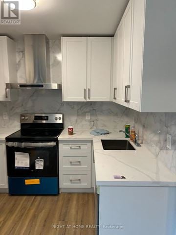 Toronto (Annex) apartment for rent - A kitchen with a stove top oven and white cabinets.