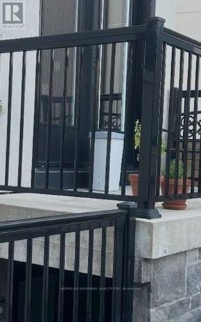 Mississauga (Lakeview) apartment for rent - A black metal railing with a stone pillar and a potted plant.