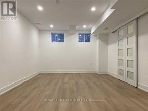 Pickering apartment for rent - A room with wooden flooring and white walls, with a window and a door visible.