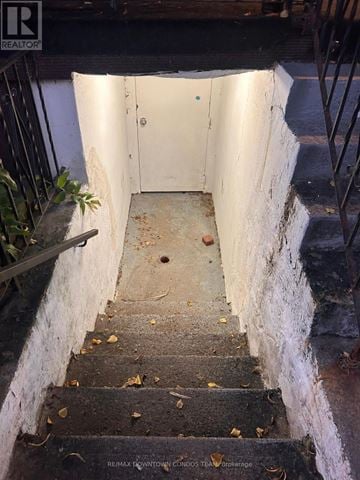 Toronto (South Parkdale) fourplex for rent - A stairway with a white door at the top.