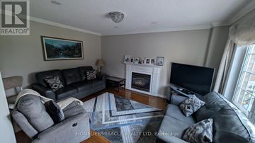 Vaughan (East Woodbridge) apartment for rent - A living room with a fireplace and a painting on the wall.
