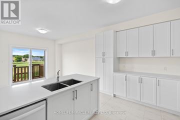 Loyalist (Bath) apartment for rent - A kitchen with white cabinets and a window overlooking a deck.