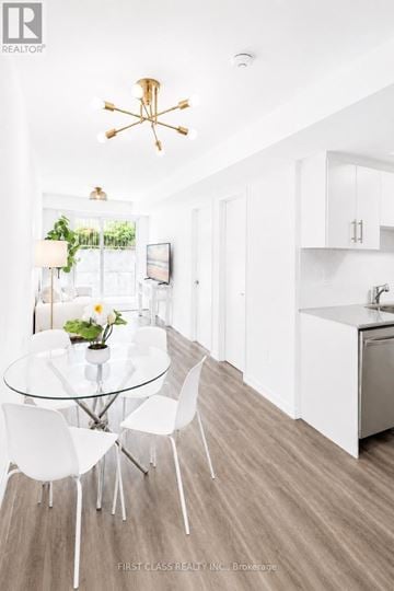 Toronto (New Toronto) townhouse for rent - A modern kitchen with a glass table and white chairs.