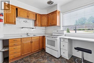 St. Catharines (Western Hill) multi-family for rent - A kitchen with wooden cabinets and white appliances.