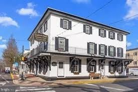 Langhorne apartment for rent - A white two-story building with black shutters and a balcony on the second floor.