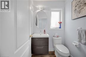 Waterdown apartment for rent - A bathroom with a toilet, sink, and mirror.