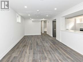 Toronto (Clairlea-Birchmount) apartment for rent - A spacious room with wooden flooring and white walls.