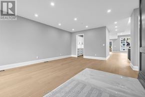 Innisfil (Stroud) apartment for rent - A spacious room with wooden flooring and white walls.