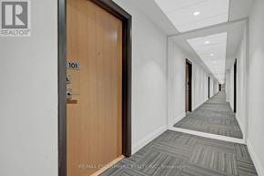 Milton (Fo Ford) condo for rent - A hallway with a door numbered 101 and a brokerage logo.