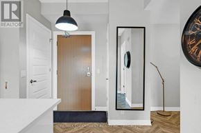 Milton (Fo Ford) condo for rent - A hallway with a wooden door, a mirror, and a lamp.