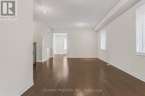 Oshawa (Kedron) apartment for rent - A spacious room with wooden floors and white walls.