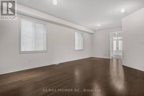 Oshawa (Kedron) apartment for rent - A spacious room with wooden flooring and white walls.