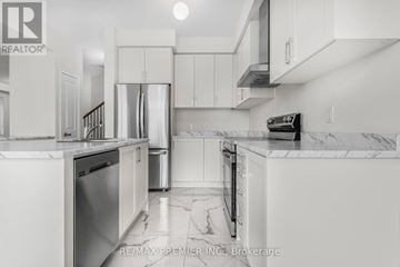 Oshawa (Kedron) apartment for rent - A kitchen with white cabinets and marble countertops.
