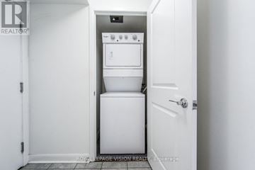 Toronto (Bendale) condo for rent - A white door is open to a small kitchen with a dishwasher and oven.