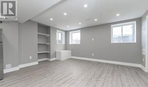 Milton (Cb Cobban) apartment for rent - A spacious room with grey walls and wooden flooring, featuring built-in shelves and a large window.