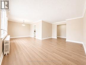 Toronto (Beechborough-Greenbrook) multi-family for rent - A spacious room with wooden flooring and white walls.